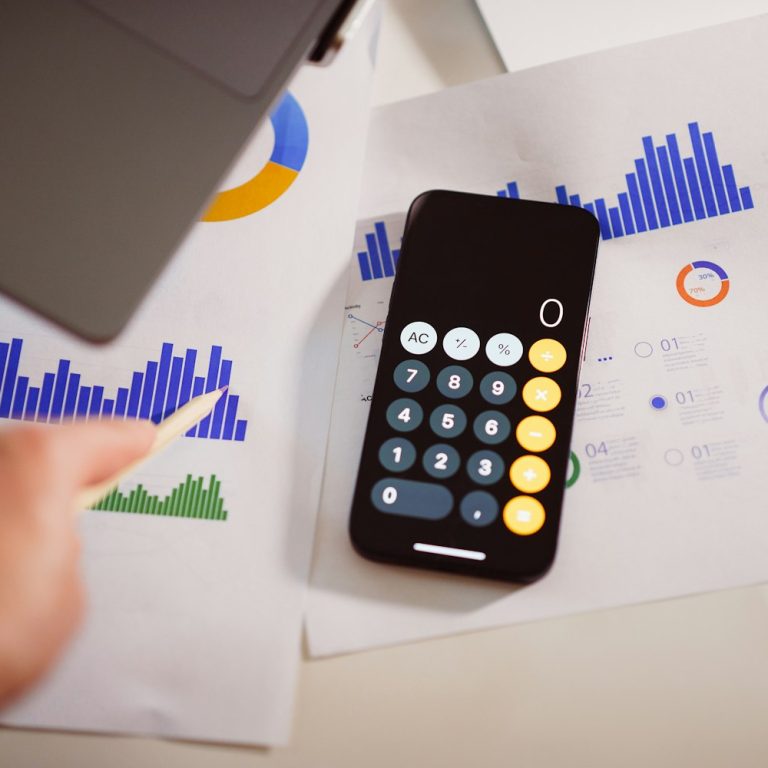 Rekenmachine op smartphone naast marketingcijfers
